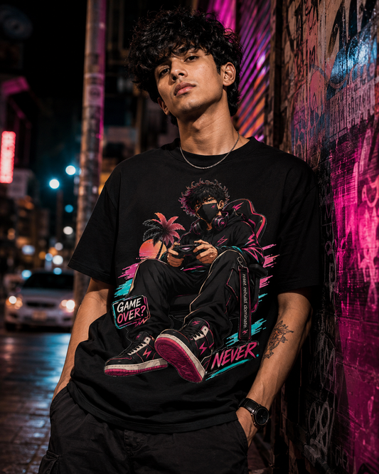 A man wearing a black graphic t-shirt with a vibrant gaming-themed print, leaning against a graffiti-covered wall at night.