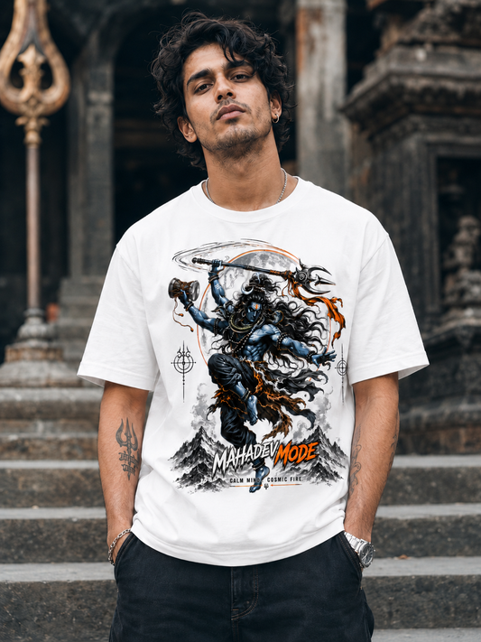 A man wearing a white graphic t-shirt with a detailed print of Lord Shiva in a fighting pose, standing in front of stone temple steps.